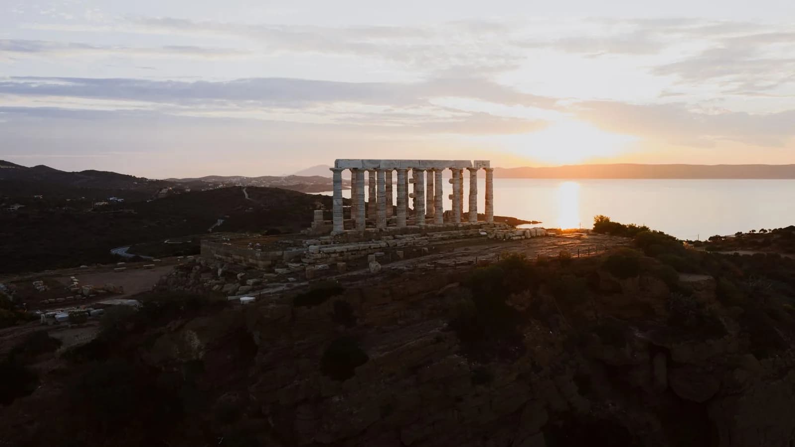 Le temple de Poséidon au cap Sounion éclairé par le coucher du soleil au-dessus de la mer Égée