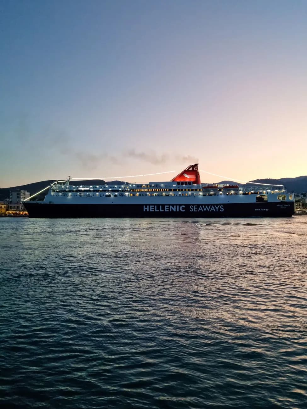 Un ferry Hellenic Seaways illuminé, accosté dans un port grec au crépuscule