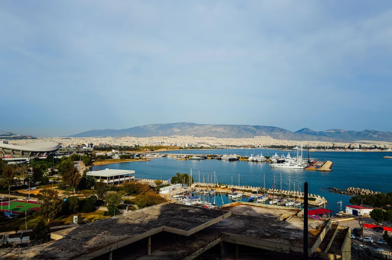Vue panoramique sur la baie du Pirée avec les navires à quai et la ville d'Athènes adossée aux montagnes