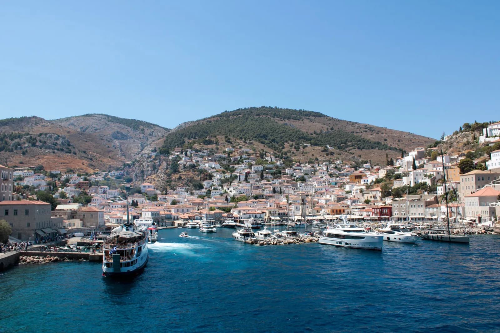 Le port d'Hydra en amphithéâtre vu depuis la mer, avec ses maisons de pierre étagées autour du bassin