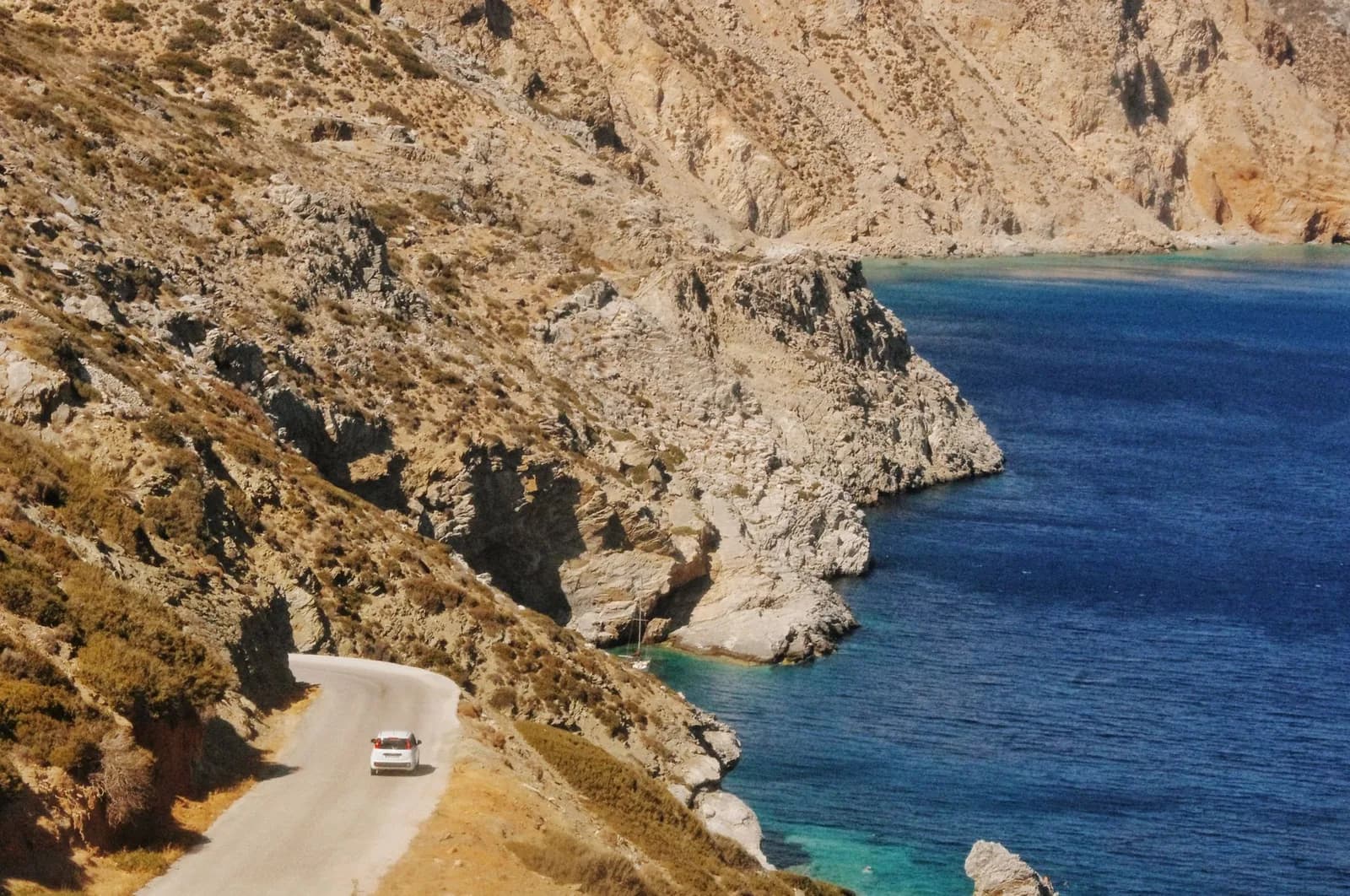 Voiture sur une route côtière dominant la mer Égée, lors d'un itinéraire d'une semaine en Grèce