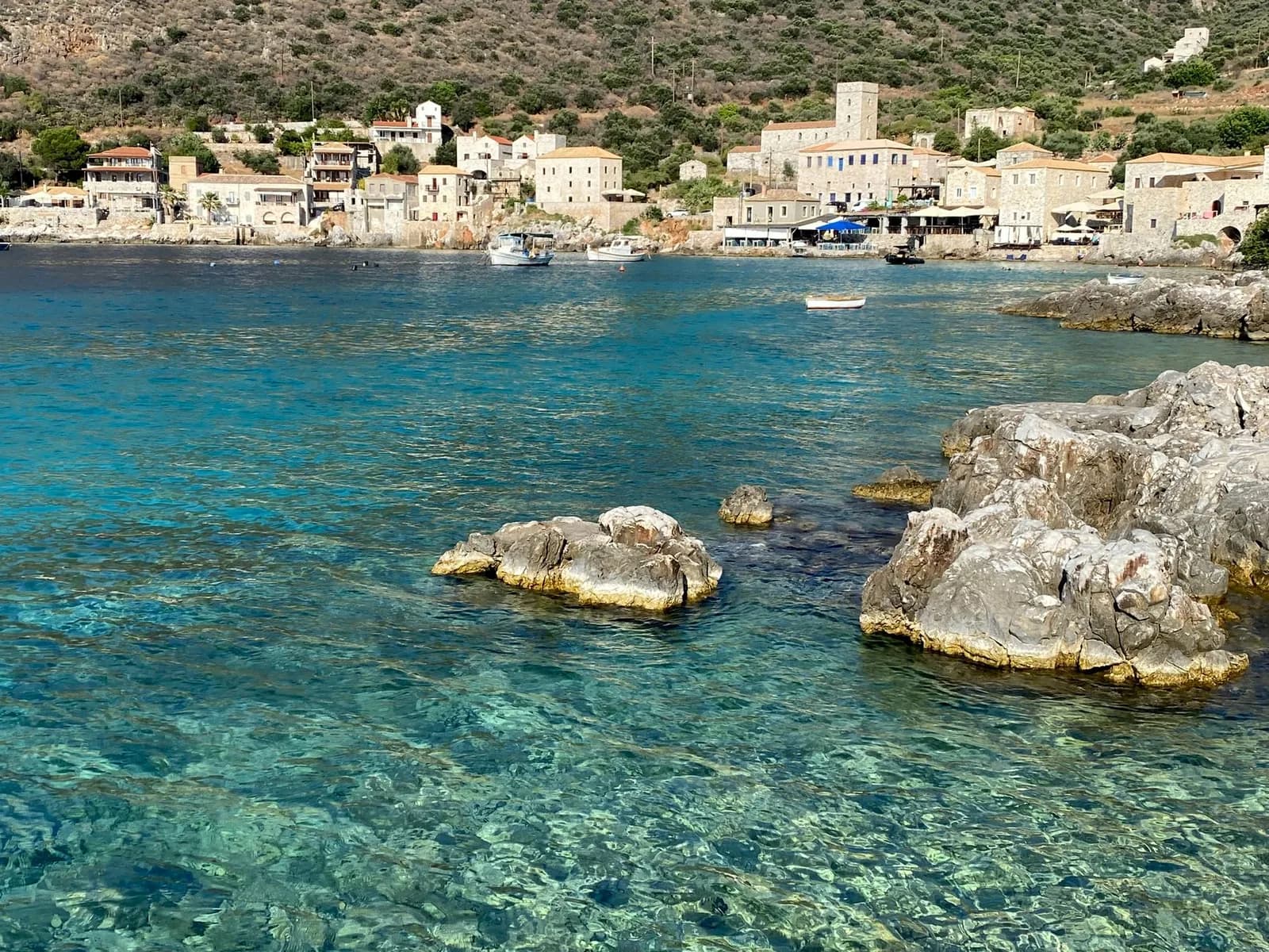 Le port de Limeni dans le Magne, ses maisons de pierre et sa tour fortifiée au bord d'une eau turquoise transparente