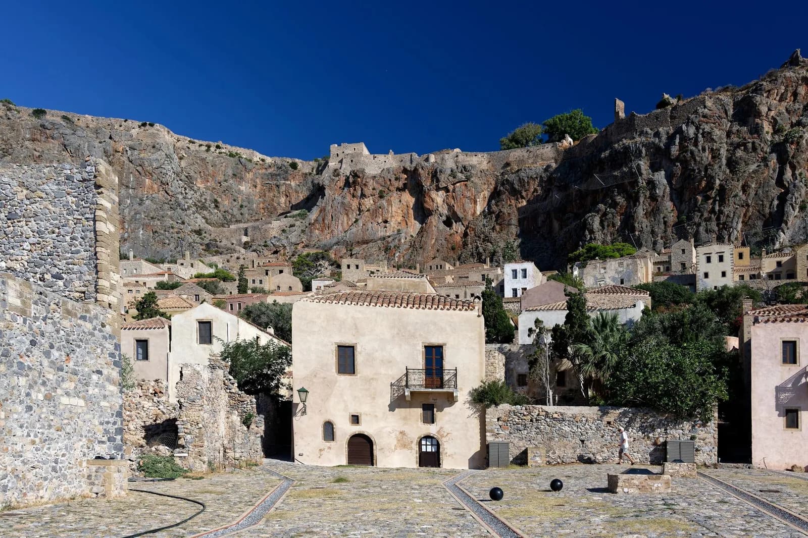 La falaise du rocher de Monemvasia dominant les maisons de pierre de la ville basse, avec les remparts de la ville haute sur la crête