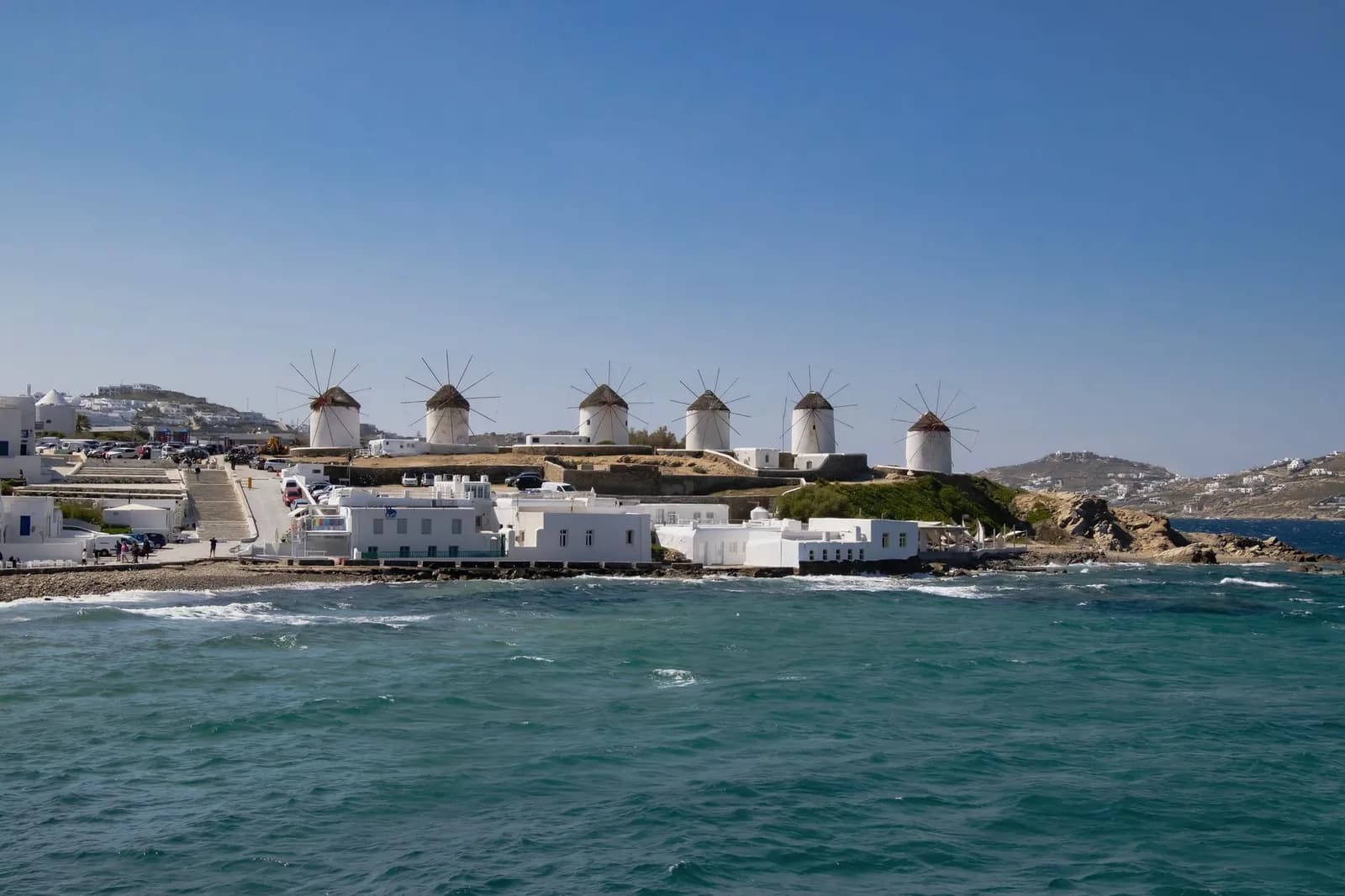 Les moulins à vent blancs de Mykonos vus depuis la mer, avec la ville de Chora en arrière-plan