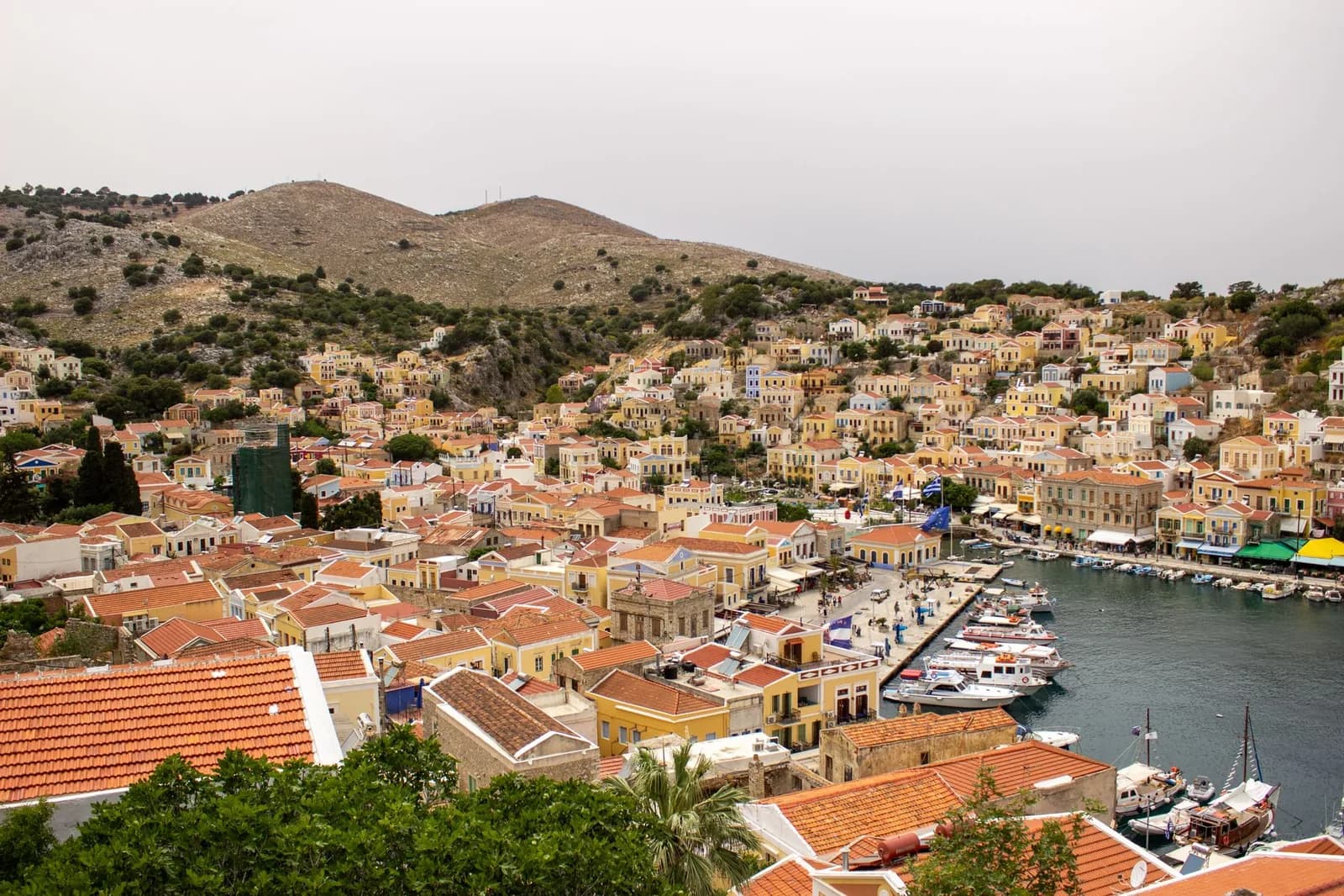 Le port de Gialos à Symi et ses maisons néoclassiques ocre étagées en amphithéâtre autour du bassin