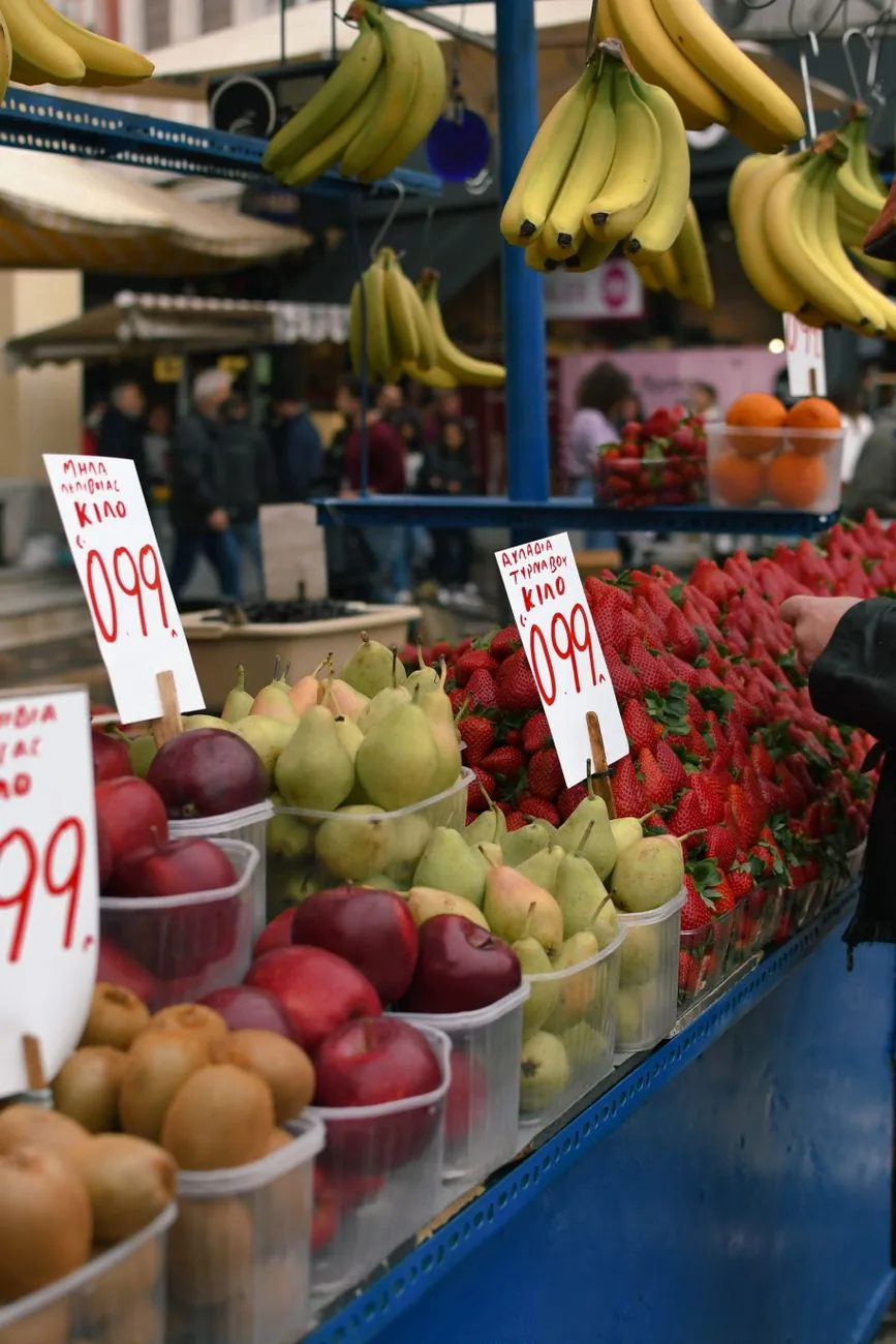 Étal de fruits et légumes d'un marché d'Athènes avec ses pancartes de prix manuscrites en grec