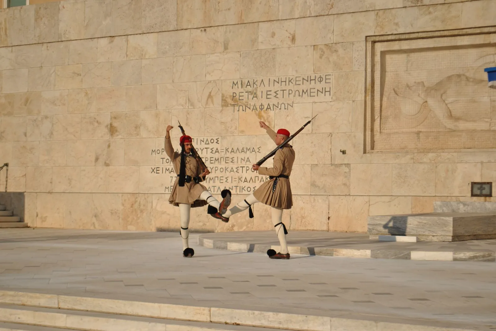 Deux evzones en fustanelle exécutant la relève de la garde devant le Tombeau du Soldat inconnu, place Syntagma à Athènes