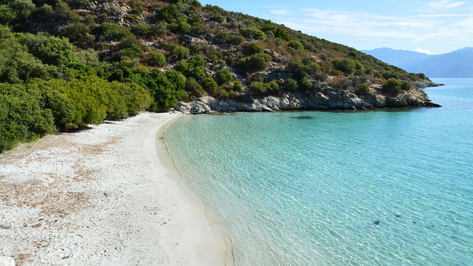 La baie d'Antisamos, ses galets blancs et son eau turquoise cernée de collines boisées, près de Sami à Céphalonie