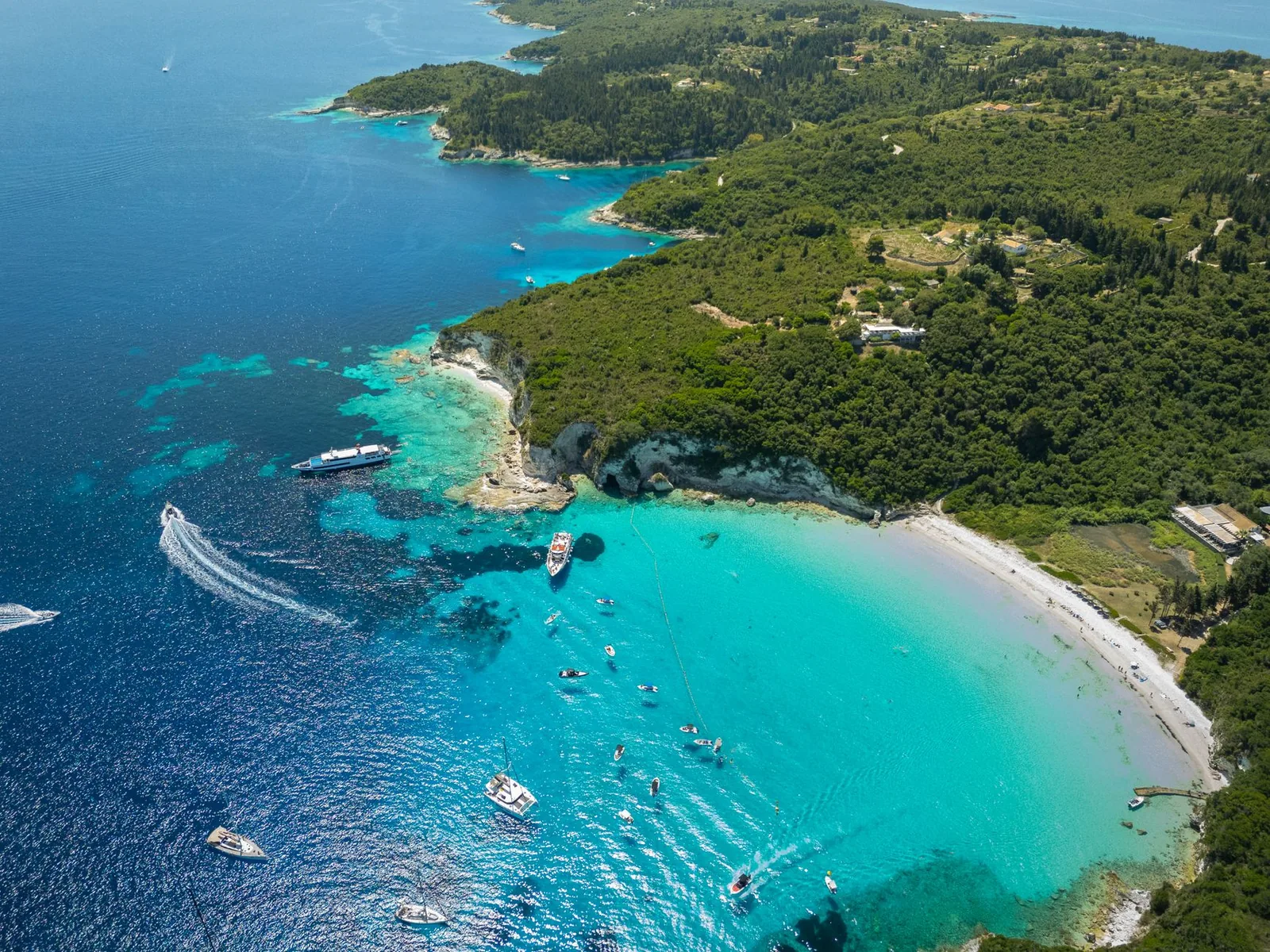 Eaux turquoise et bateaux d'excursion le long de la côte d'Antipaxos, au sud de Corfou