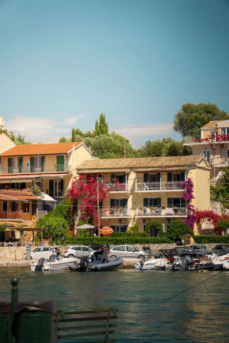 Maisons fleuries et barques dans le port de Kassiopi, sur la côte nord-est de Corfou