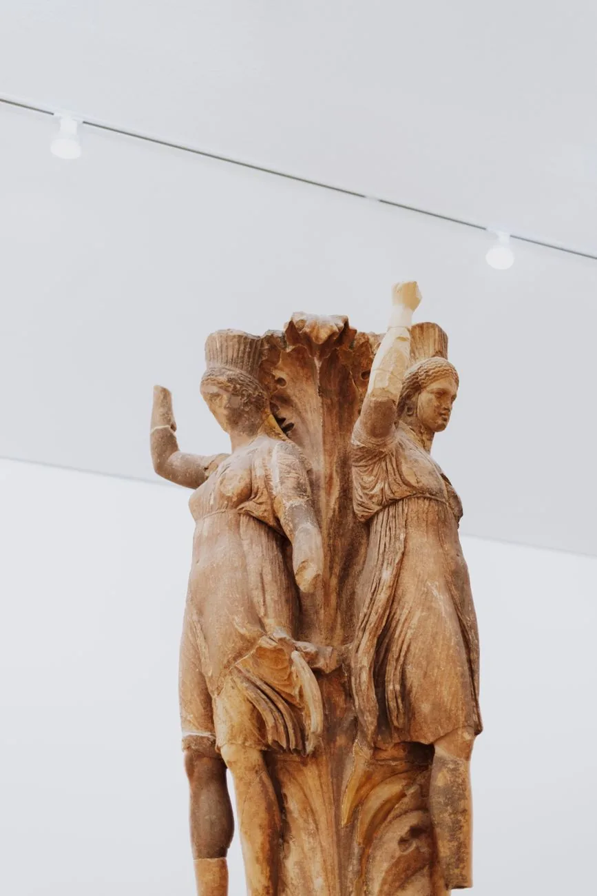 La colonne aux danseuses de Delphes, sculpture de trois jeunes filles sur un chapiteau d'acanthe, au musée archéologique de Delphes