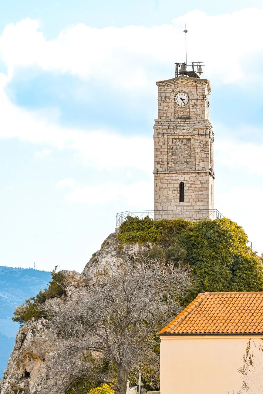 La tour de l'horloge en pierre perchée sur son rocher au-dessus des toits d'Arachova, près de Delphes