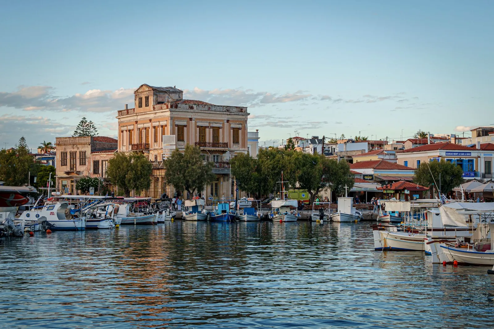 Le port d'Égine et ses caïques amarrés devant les façades néoclassiques du front de mer