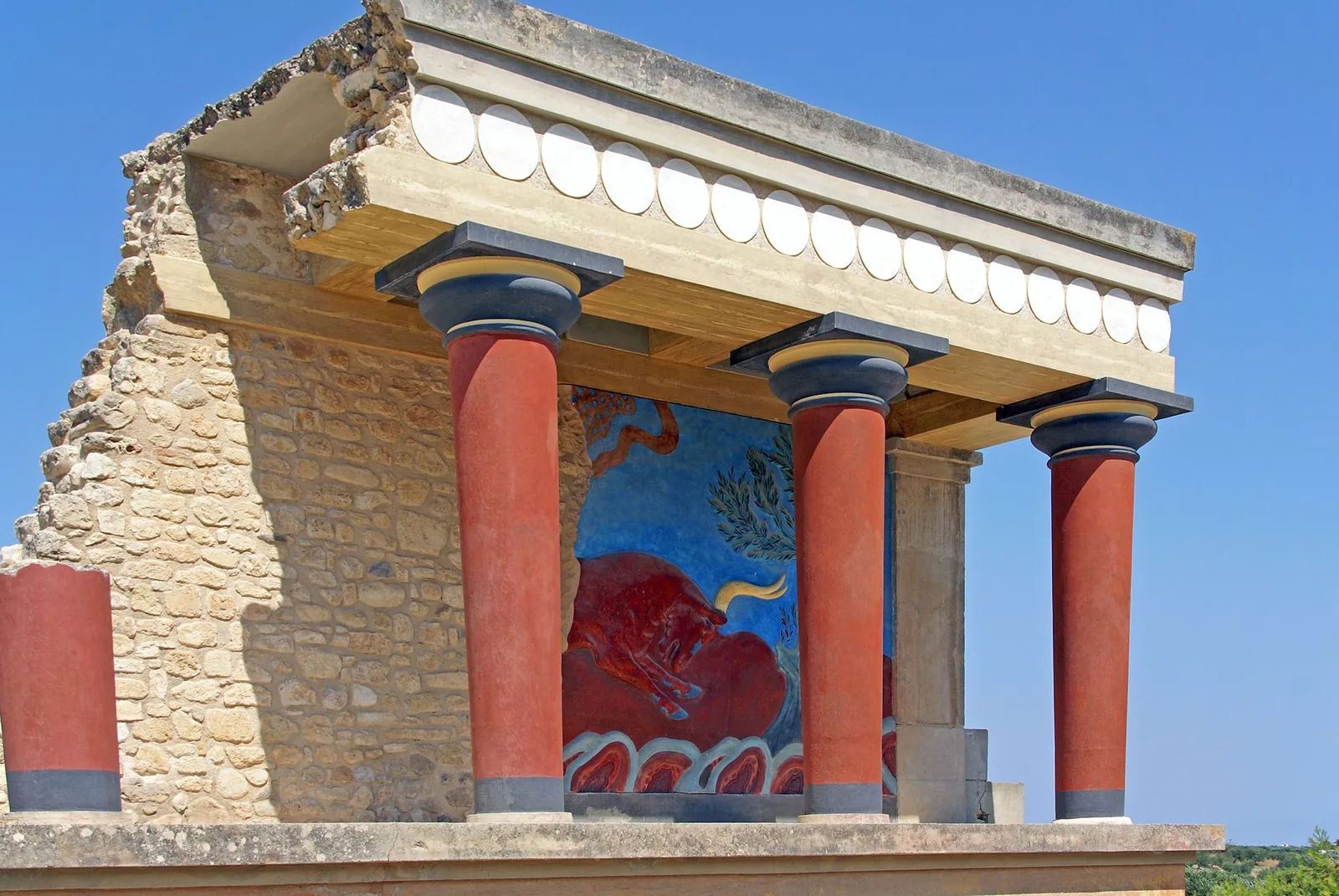Les colonnes rouges reconstituées et les vestiges du palais minoen de Knossos près d'Héraklion en Crète, sous un ciel bleu