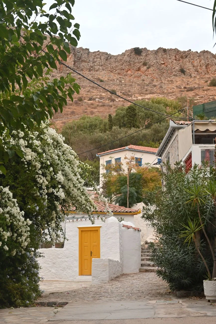Ruelle dallée bordée de murs blancs et de bougainvillées montant vers le village haut d'Hydra