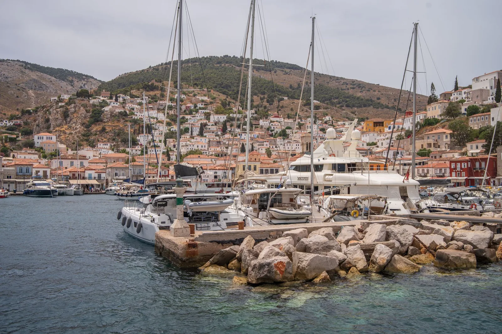 Voiliers et bateaux amarrés dans le port d'Hydra devant les maisons de pierre aux toits de tuiles