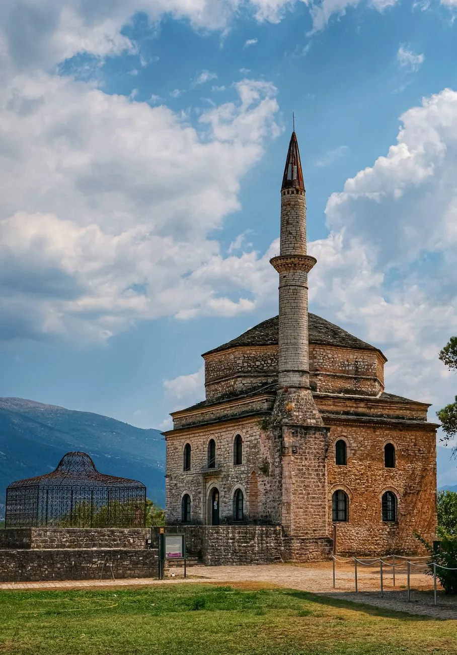 Mosquée ottomane en pierre et son minaret dans l'enceinte du Kastro d'Ioannina, sur fond de montagnes