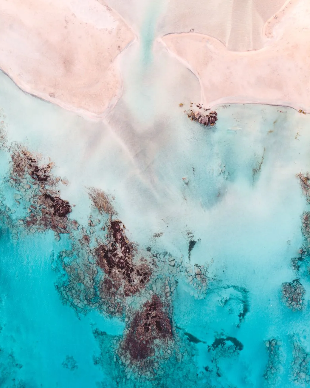 La plage d'Elafonissi en Crète avec son sable teinté de rose par les coquillages, des eaux cristallines turquoise et la petite île en arrière-plan