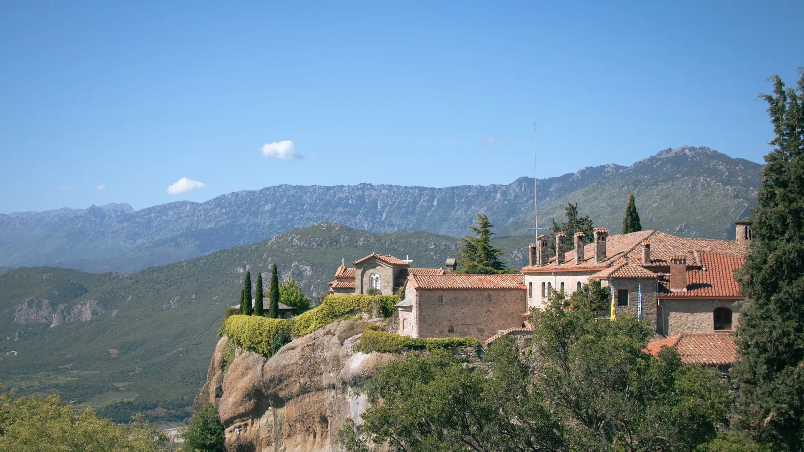 Le monastère d'Agios Stefanos et ses toits de tuiles au bord de la falaise, face à la plaine de Thessalie, aux Météores