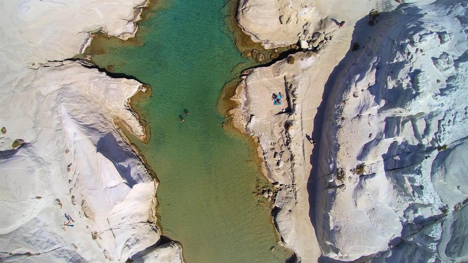 Les roches volcaniques blanches et lisses de Sarakiniko à Milos, sculptées en vagues de pierre au bord d'une mer turquoise