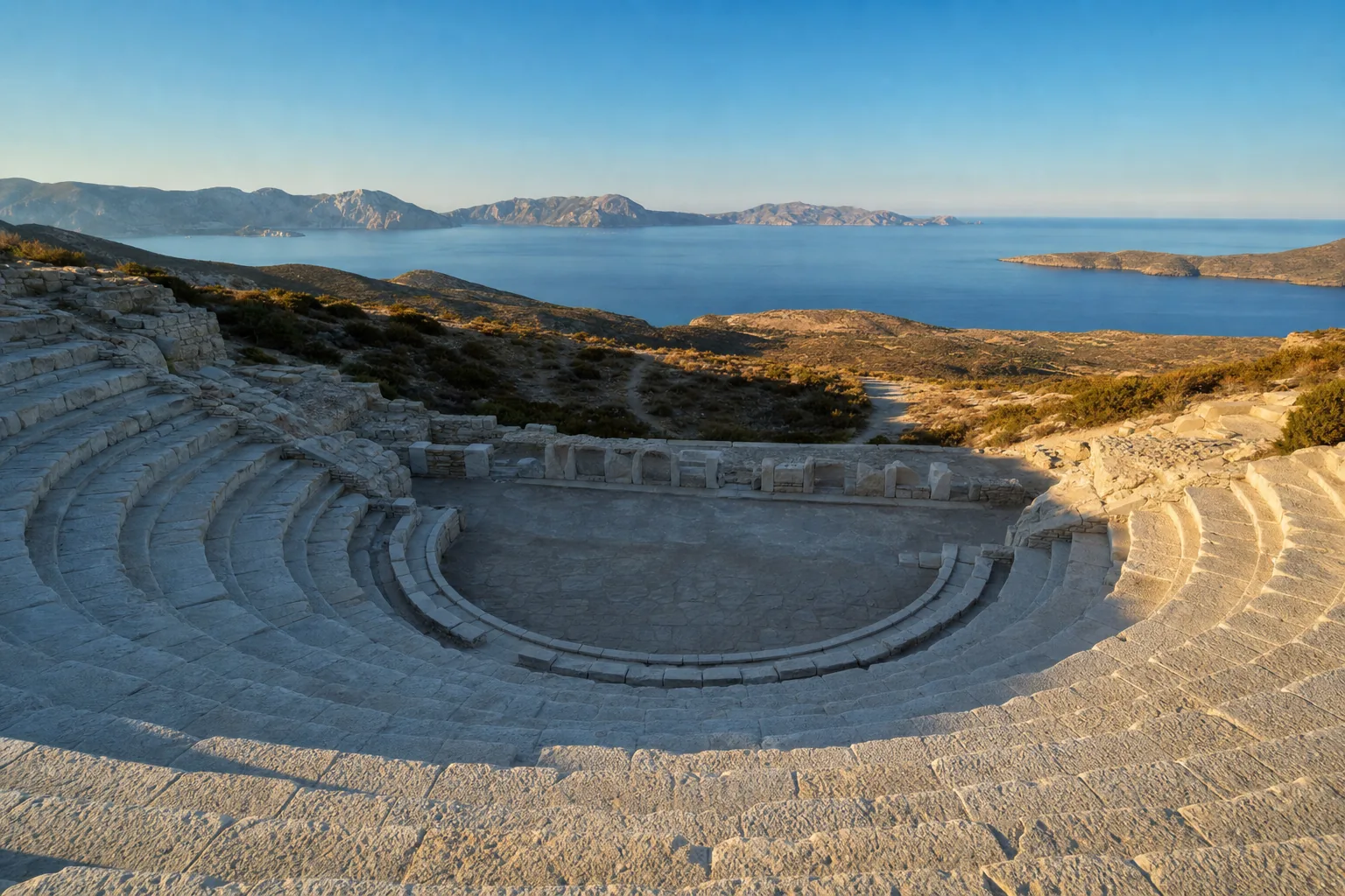 Les gradins de marbre en hémicycle du théâtre antique de Milos, à Tripiti, ouverts sur la baie et la mer Égée