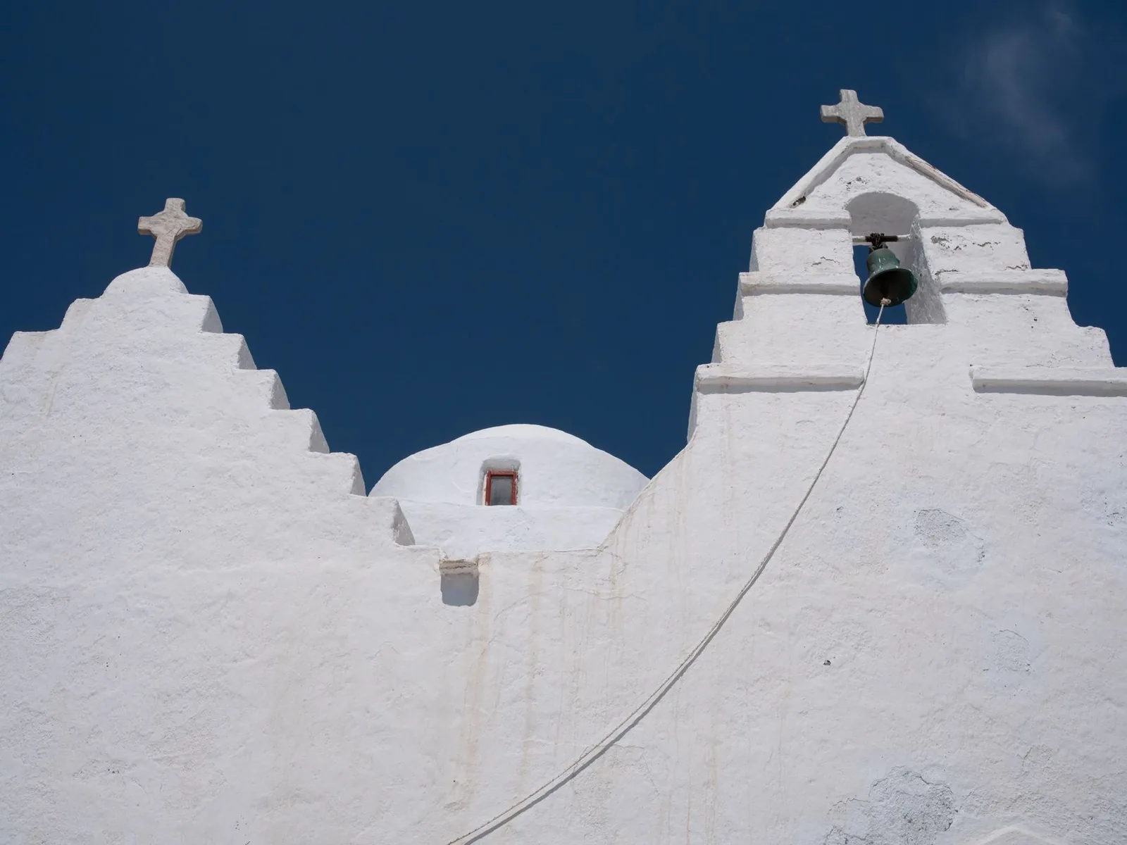Clocher à degrés et coupole d'une église blanche traditionnelle de Mykonos