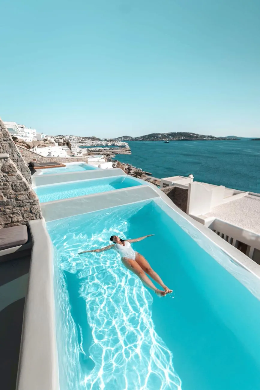 Piscine à débordement d'un hôtel de Mykonos surplombant la baie et la ville blanche