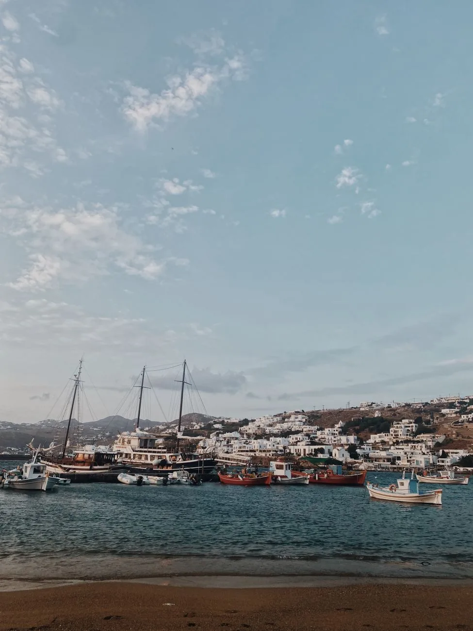 Vieux port de Mykonos au crépuscule, caïques en bois amarrés devant la ville blanche