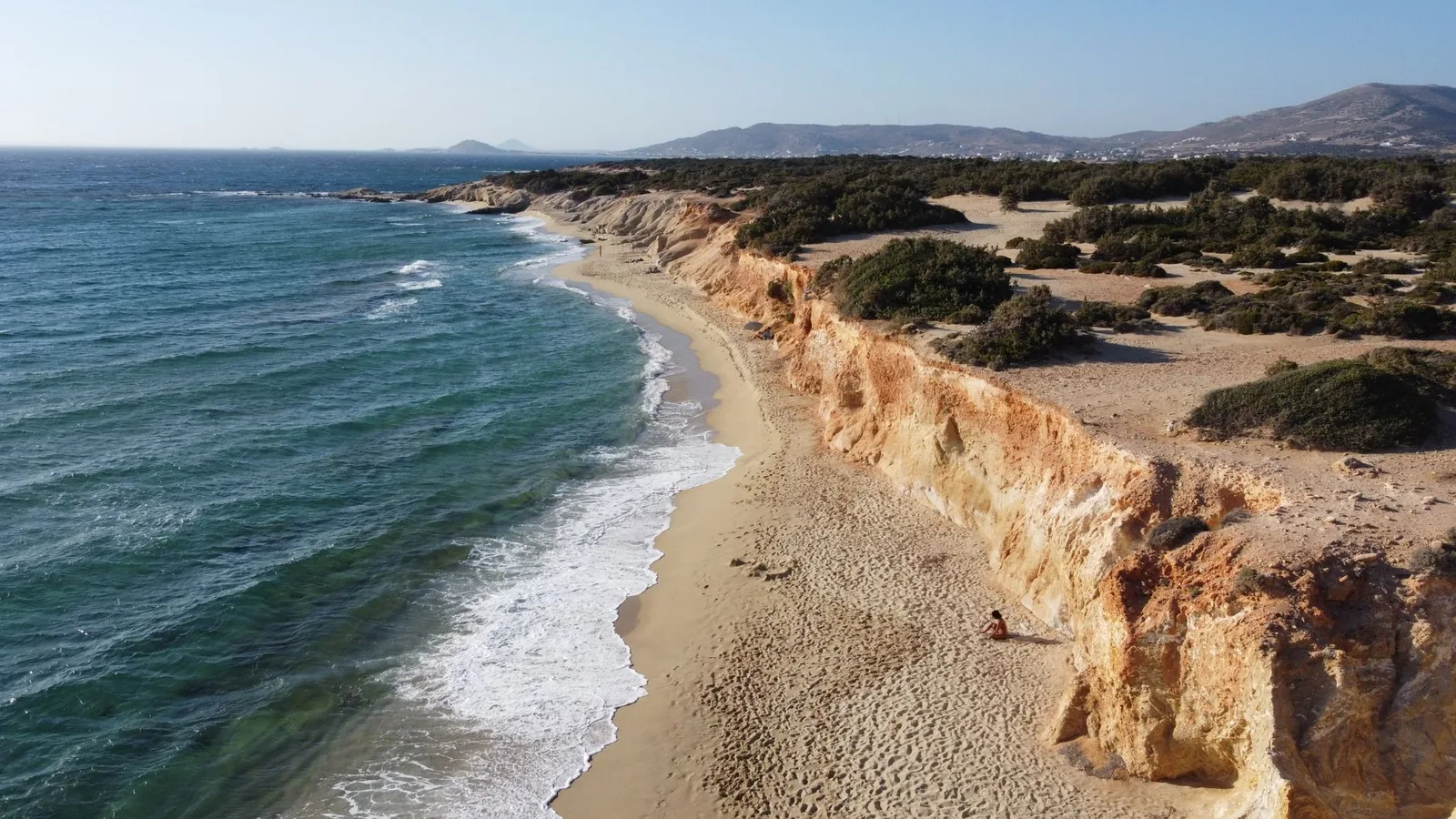 Longue plage de sable et dunes de Plaka, bordée d'eau turquoise sur la côte ouest de Naxos