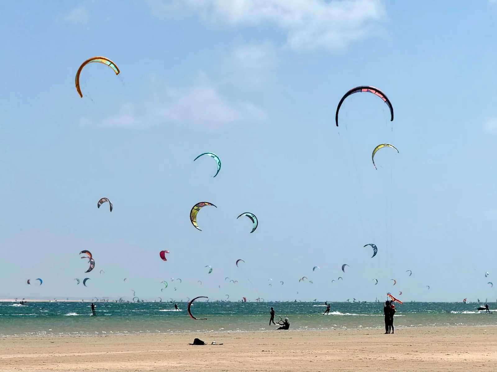 Planche de windsurf floquée « Paros » plantée dans le sable doré face à la mer turquoise de Golden Beach