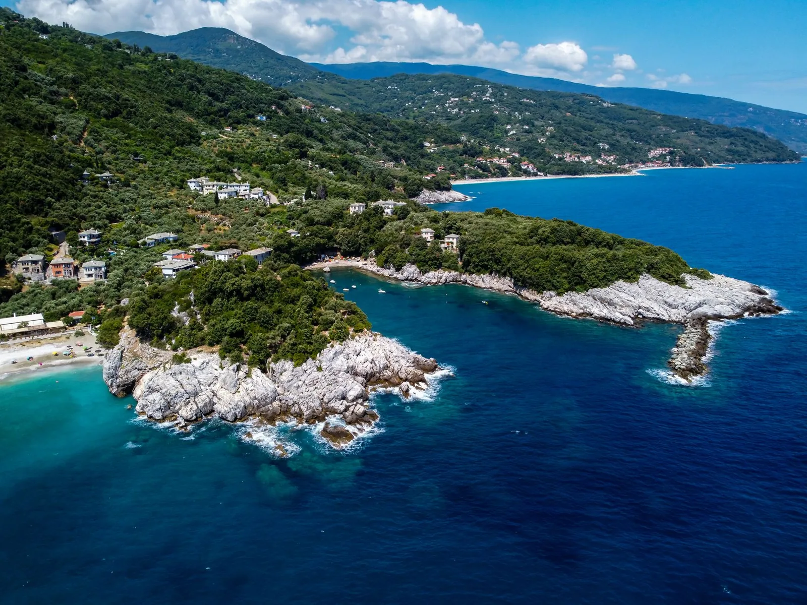 Vue aérienne de la crique de Damouchari et de sa pointe rocheuse sur la côte est du Pélion, avec la plage d'Agios Ioannis au fond