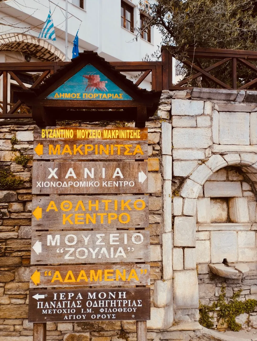 Panneaux de direction en bois à Portaria, dans le Pélion, indiquant Makrinitsa et le centre de ski de Chania, au dessus d'une fontaine de marbre
