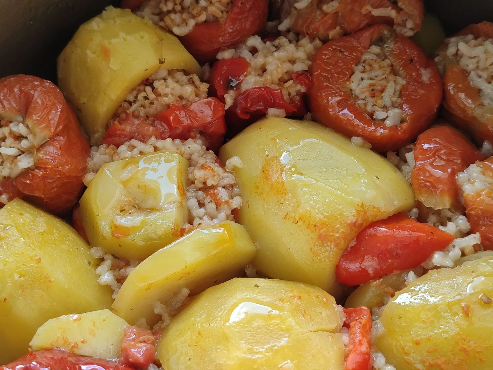 Gemista grecs, tomates et poivrons farcis au riz et aux herbes, cuits au four sur un lit de pommes de terre