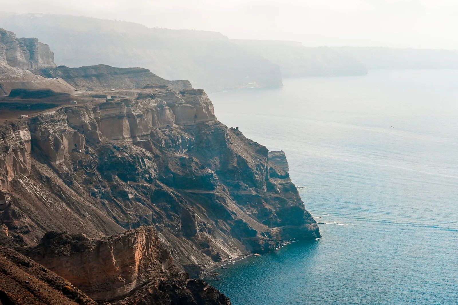 Falaises volcaniques striées de la caldeira de Santorin vues depuis la mer