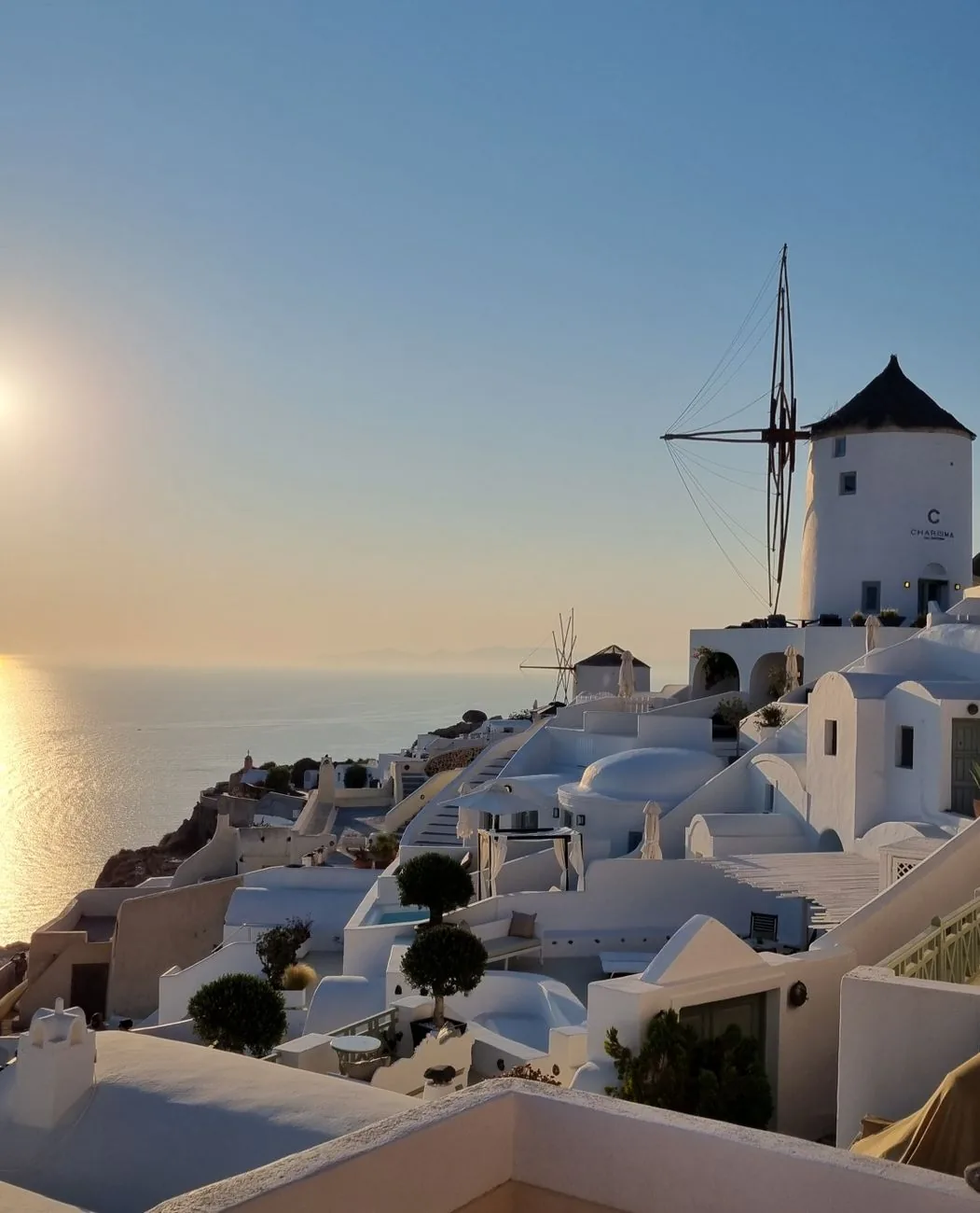 Coucher de soleil sur les moulins et les maisons blanches d'Oia à Santorin
