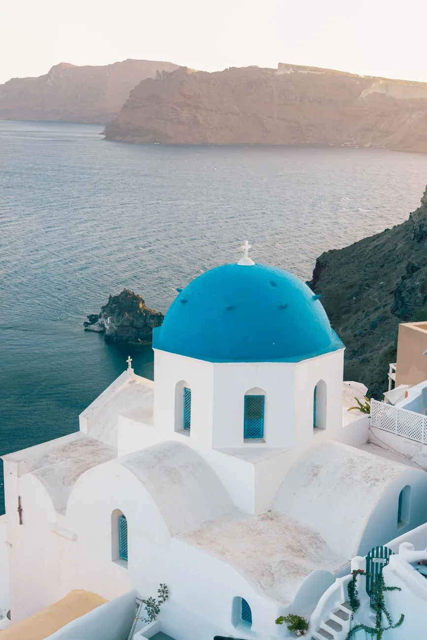 Église à coupole bleue d'Oia surplombant la caldeira de Santorin