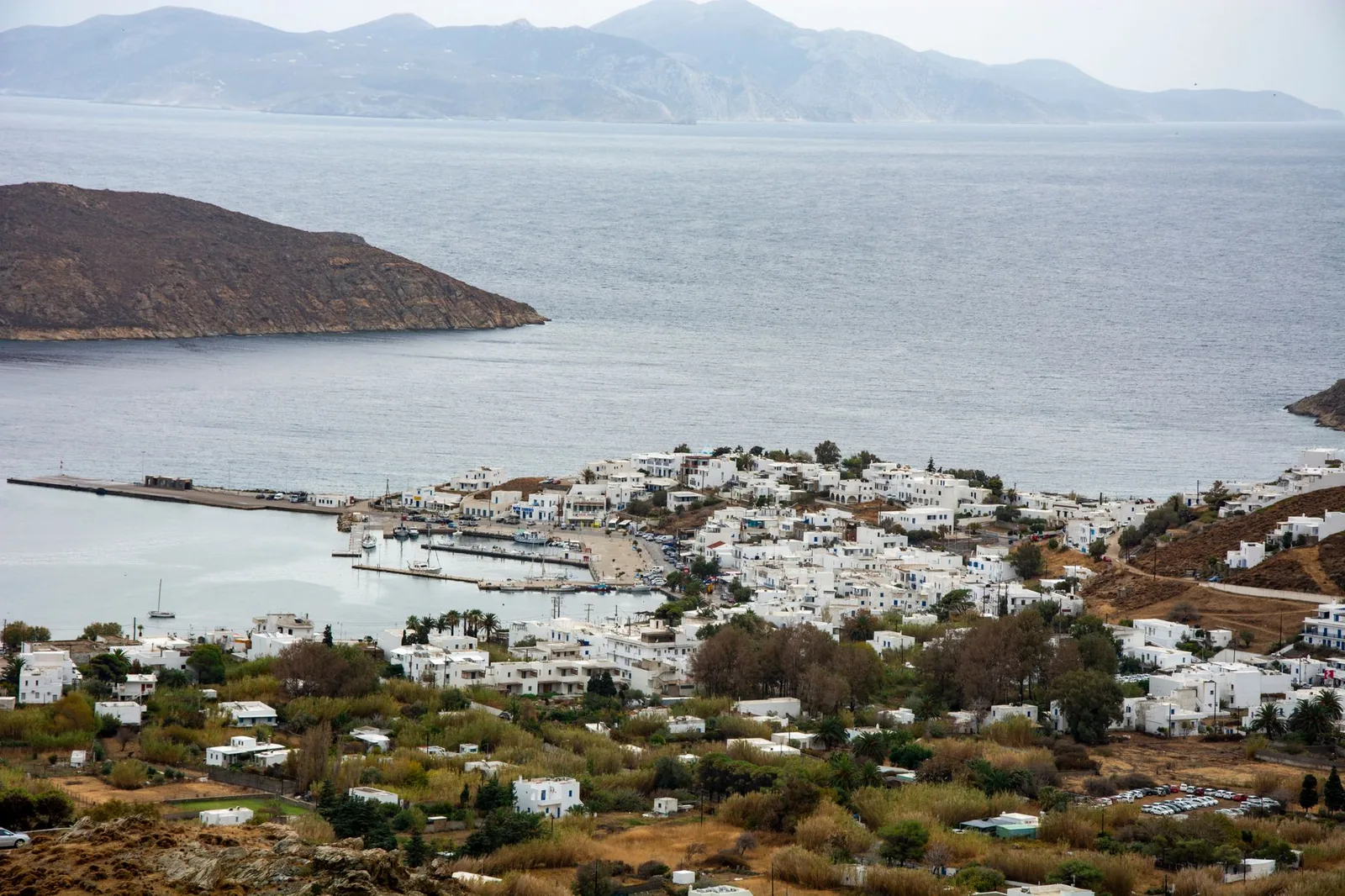 Le port et le village de Livadi vus depuis les hauteurs de la Chora de Sérifos, avec la jetée, les maisons blanches au bord de la baie et Sifnos à l'horizon
