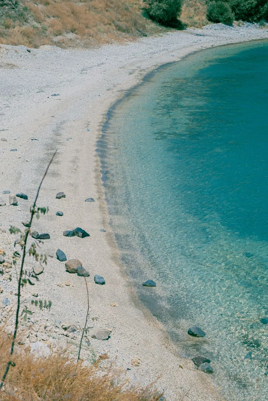 Crique abritée aux eaux turquoise parfaitement calmes et au rivage de sable clair, dans la baie de Vathi à Sifnos