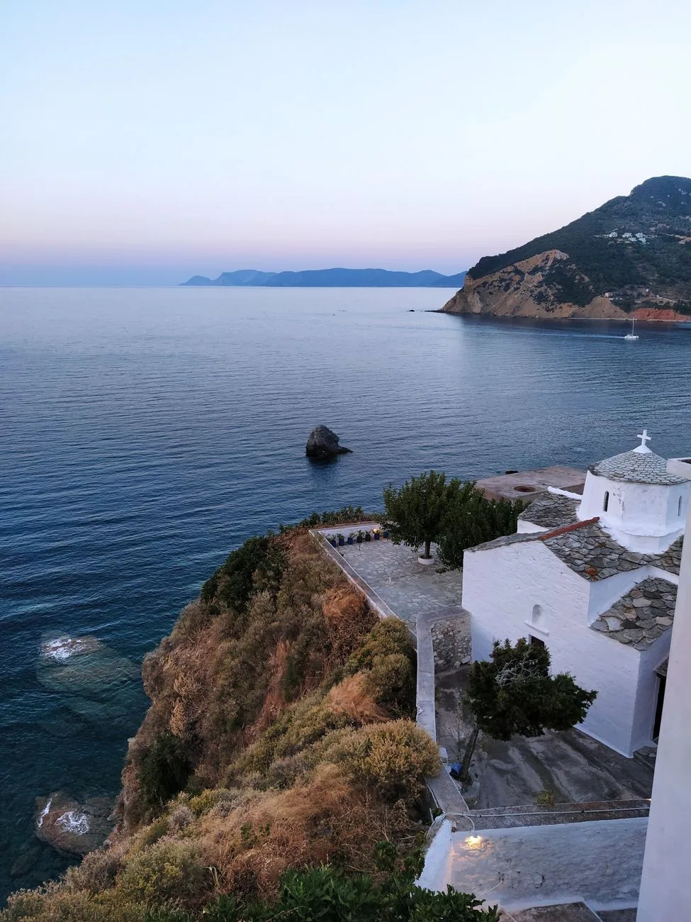 L'église blanche de la Panagitsa tou Pyrgou au bord de la falaise de Skopelos Ville, au dessus de la mer au crépuscule