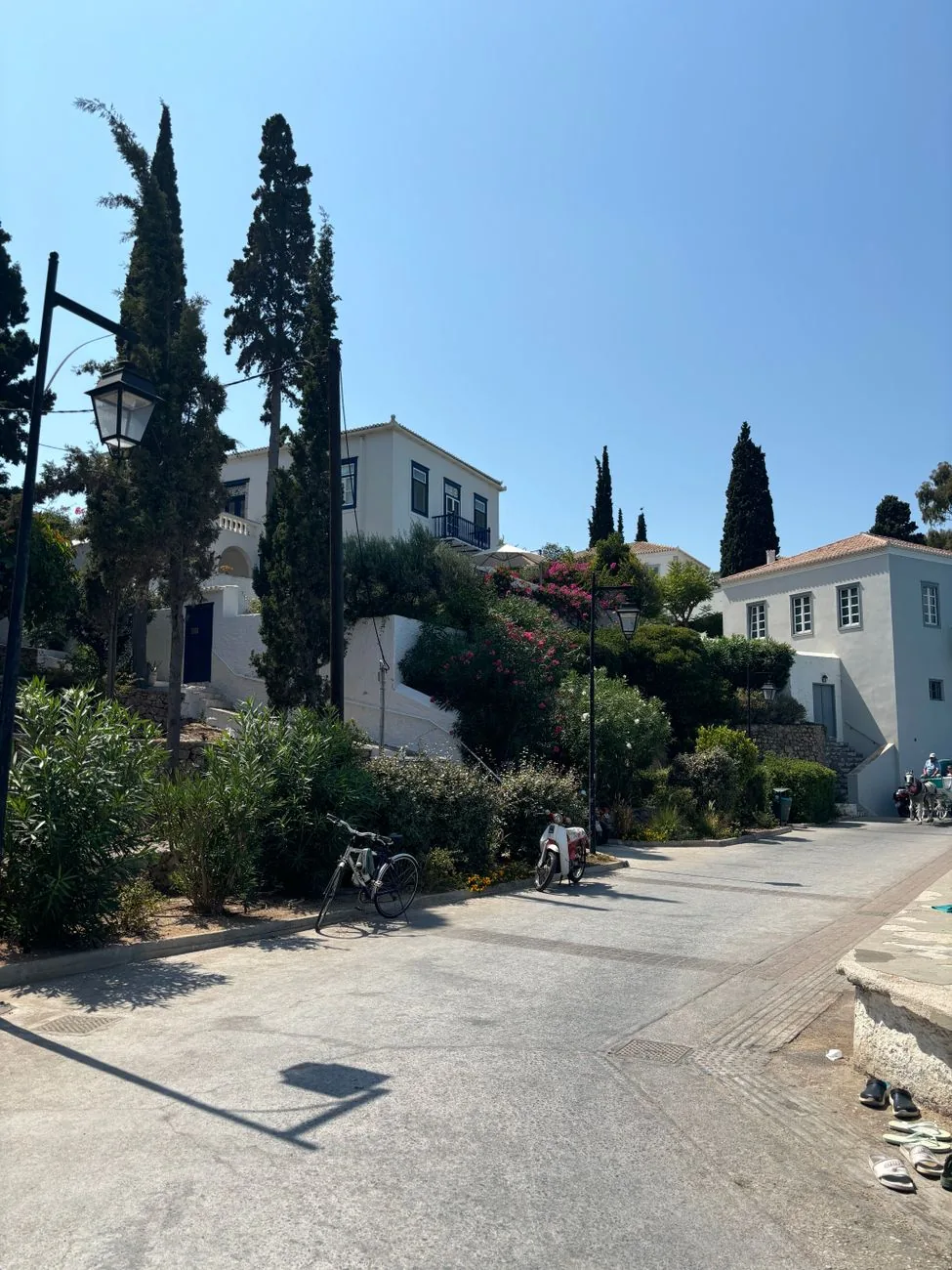 Rue sans voitures bordée de demeures d'armateurs blanches, de cyprès et de jardins à Spetses