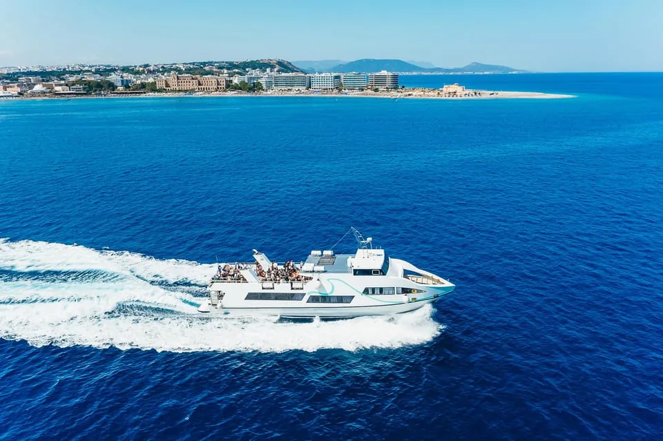 Hors-bord rapide quittant la côte de Rhodes en direction de Symi, sillage blanc sur la mer bleue