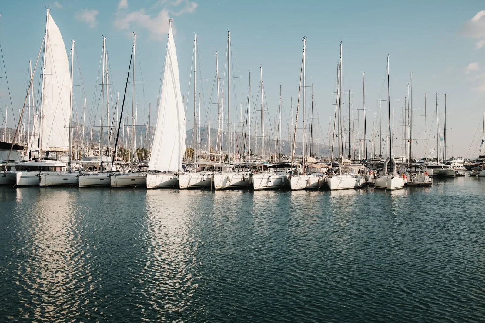 Voiliers amarrés dans une marina du Péloponnèse, avec les montagnes au loin