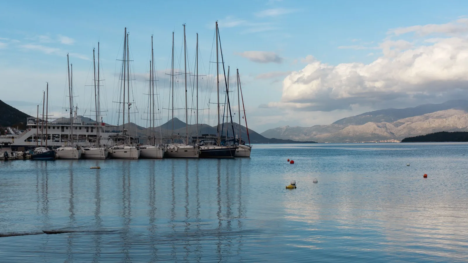 Voiliers amarrés dans le port de Nydri, sur la côte est de Lefkada, face aux reliefs de l'autre côté de la baie