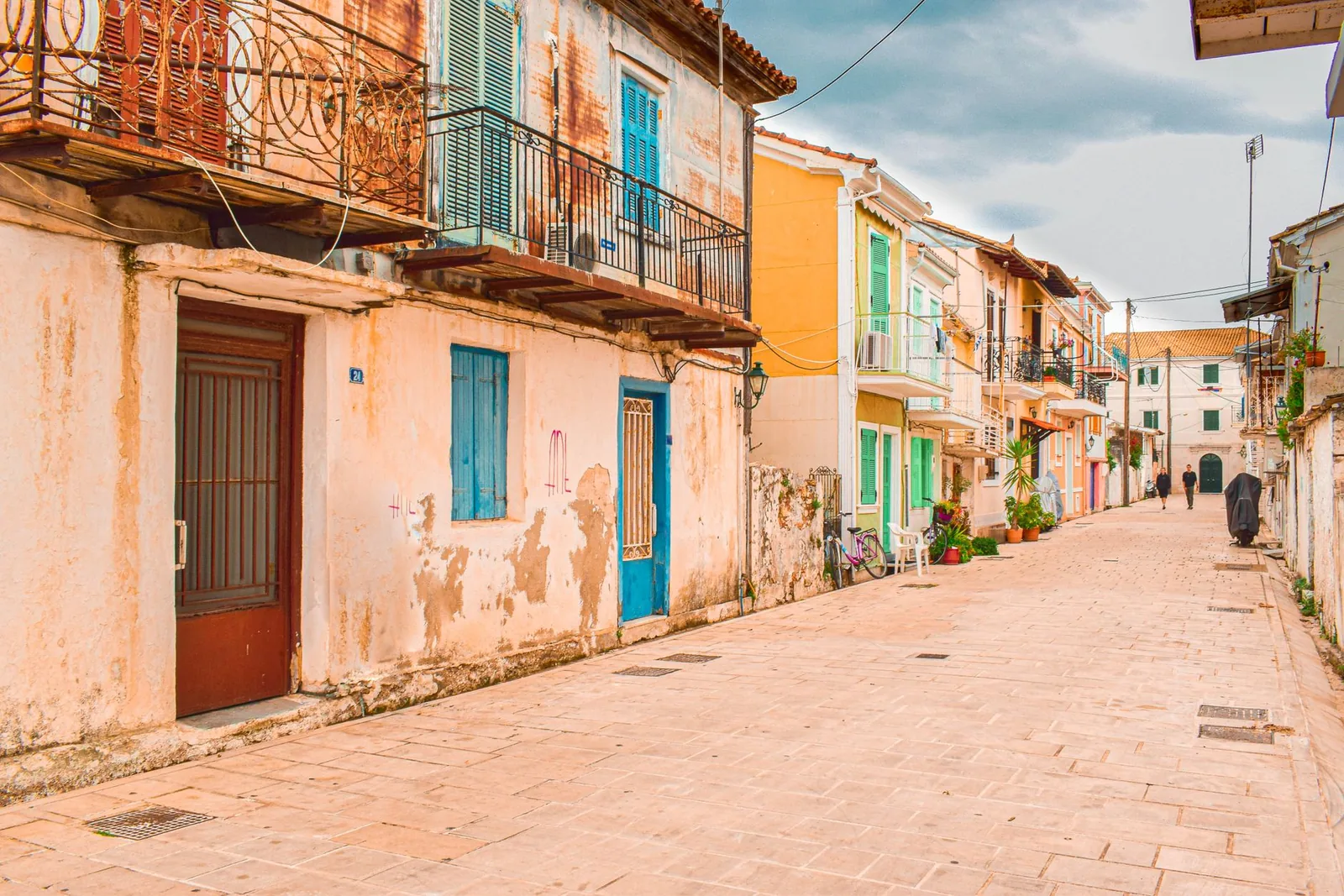 Ruelle dallée du vieux centre de Lefkada ville, bordée de maisons aux façades pastel et aux balcons en fer forgé